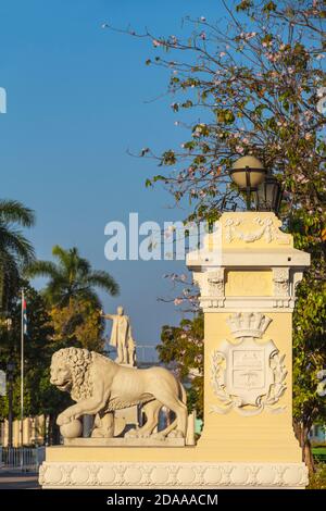 Kuba, Cienfuegos, Parque Martí, Steinlöwe am Eingang des Parks, in der Ferne ist Marmorstatue von Jose Marti - ein kubanischer Revolutionär und Intellektueller Stockfoto