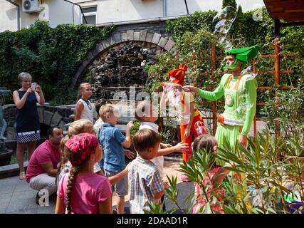 UZHGOROD, UKRAINE - 20. August 2015: Clowns zeigen Kindern Seifenblasen während eines Kinderurlaubs. Kinder und Erwachsene spielen Seifenblasen Stockfoto