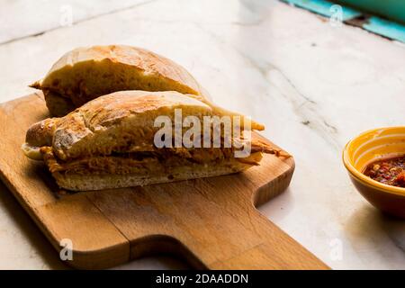 Sehr leckeres großes Sandwich mit Fleisch gefüllt und hausgemachtem knusprigen und flauschigen Brot. Es ist ein traditionelles portugiesisches Schweinefleisch Rindfleisch Sandwich 'bifana' Stockfoto