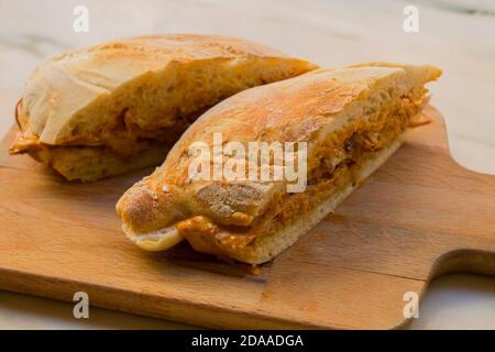 Sehr leckeres großes Sandwich mit Fleisch gefüllt und hausgemachtem knusprigen und flauschigen Brot. Es ist ein traditionelles portugiesisches Schweinefleisch Rindfleisch Sandwich 'bifana' Stockfoto