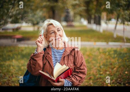 Porträt von nachdenklichen konzentriert beschäftigt ältere Frau mit Notizblock und Stift in den Händen Planung, expertising, Denken. Bildung, Studium Fremdsprachen Konzept, Kopierraum. Stockfoto