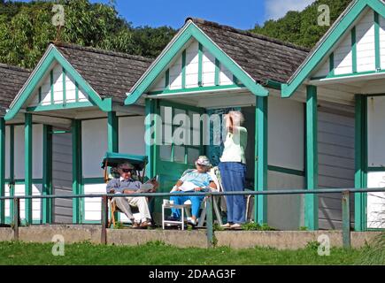 Menschen, die sich in den Strandhütten an der Langland Bay bei Swansea entspannen. Stockfoto