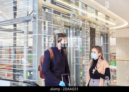 Geschäftsreisende mit Gesichtsmasken auf Geschäftsreisen in der flughafen während der Covid-19 Pandemie Stockfoto