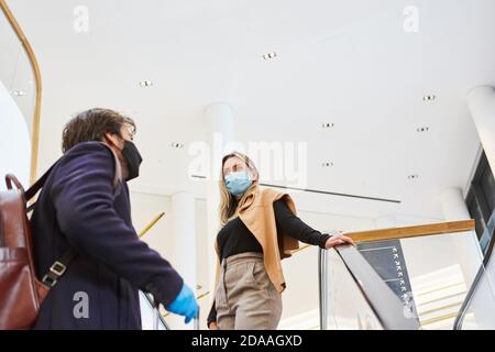 Geschäftsreisende auf Geschäftsreise mit Gesichtsmasken im flughafen während der Covid-19 Pandemie Stockfoto