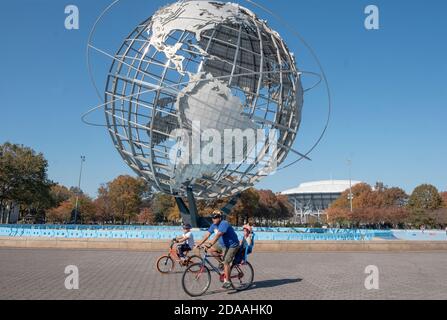 An einem milden Herbsttag, ein , Familie Fahrräder rund um den Umfang der Unisphere in Flushing Meadows Corona Park in Queens, New York City Stockfoto