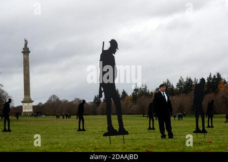 Bob Amis aus Oxfordshire, der beim 5. Bataillon der Royal Green Jackets diente, steht unter zweihundert Silhouetten von Soldaten, die der Witney-basierte Künstler Dan Barton in Blenheim Palace Gardens in Woodstock, Oxfordshire, geschaffen hat, um an die Kriegstoten am Waffenstillstandstag zu erinnern. Stockfoto