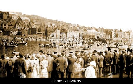 Eine seltene alte echte Fotopostkarte, die die jährliche Regatta in Whitby, Yorkshire, UK, möglicherweise in den 1920er Jahren zeigt? Die Menschenmassen beobachten ein Ruderkegel (sprich: Kob-el) Rennen zwischen lokalen Fisch- und Muschelfischer auf dem Fluss Esk. Cobles sind kleine Klinker-gebaute Fischerboote mit einer flachen Basis, die angeblich in der Zeit bis zu Eary Viking Siedler an dieser Küste zurückreichen. Stockfoto