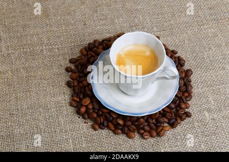 Tasse Espresso umgeben von Kaffeebohnen. Winkelansicht. Stockfoto