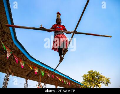 Ein indisches Mädchen führt Straße Akrobatik durch Wandern auf dem engen Seil auf pushkar Kamel Festival. Stockfoto