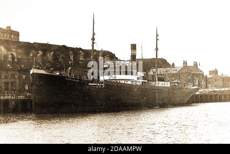 Ein frühes Pressefoto eines einzigen geschlemmten, zweimastigen Frachtschiffes, das im unteren Hafen von Whitby Yorkshire um die 40er Jahre festgemacht wurde (der Name ist uneindeutig). Das Gebiet hinter dem Kai ist lokal als Spin Kop bekannt, durch das eine tiefe Schlucht führt, die Khyber Pass genannt wird, ein Hinweis auf die afghanischen Kriege Stockfoto