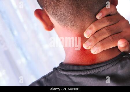 Mann, der zu Hause an Nacken- oder Schulterschmerzen leidet. Stockfoto
