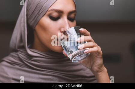 Porträt Der Arabischen Frau Trinkwasser Aus Glas In Der Küche Stockfoto