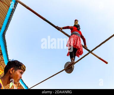 Ein Mädchen führt Straße Akrobatik durch Wandern auf engen Seil auf pushkar Kamel Festival. Stockfoto