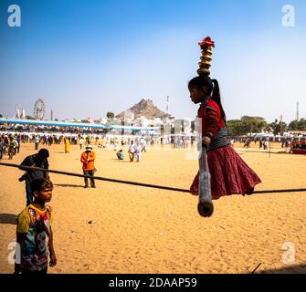 Ein Mädchen führt Straße Akrobatik durch Wandern auf engen Seil auf pushkar Kamel Festival. Stockfoto