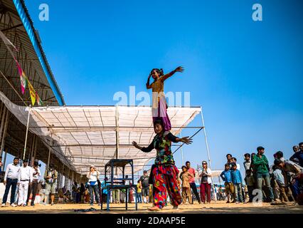 Ein Mädchen führt Straßenakrobatik und Straßenshow für Geld Auf pushkar Kamel Festival Stockfoto