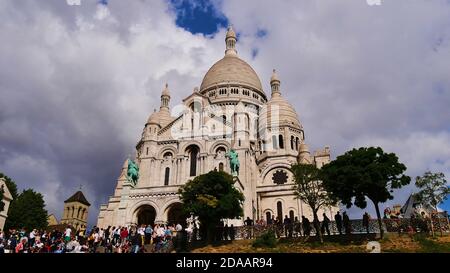 Touristenmassen genießen die Aussicht vor der majestätischen Basilika des Heiligen Herzens (Sacre-Coeur Basilika) von Paris, Frankreich auf Montmartre. Stockfoto