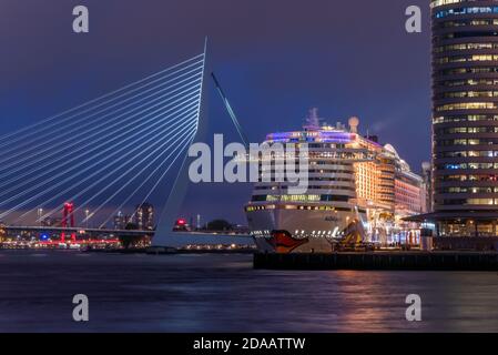 Rotterdam, Niederlande - 2. Mai 2019 : AIDAperla Kreuzfahrtschiff der deutschen AIDA Cruises Firma stationiert am Kreuzfahrtterminal am Fluss Nieuwe Maas gegen die erasmusbrücke in der Nacht. Stockfoto