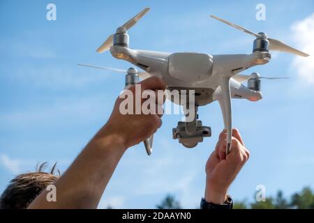 Nahaufnahme des Drohnenpiloten, der sich auf den Flug im Freien vorbereitet. Ferngesteuerter Drohnenroboter. Stockfoto