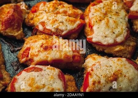 Gebackenes Hähnchenfilet mit Käse und Tomate auf einem Backblech zum Braten. Fleischgericht für den Festtisch. Stockfoto