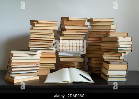 Großer Stapel Bücher auf dem Tisch. Vor der Prüfung studieren. Stapel von alten Büchern. Konzept der Bildung und Studium Stockfoto