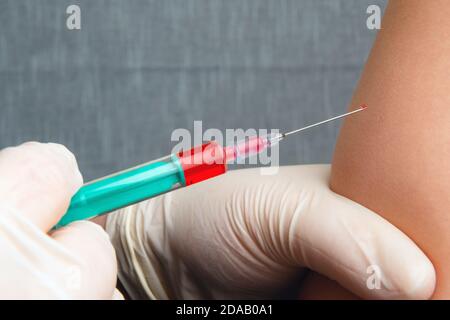 Nahaufnahme der Hände der Krankenschwester, die einen Grippeimpfstoff in die Schulter des Patienten geben. Arzt, der infizierte Personen geimpft. Injizierende Corona-Viren, Kovid-19, Influen Stockfoto