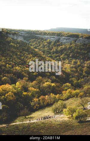 Gruppe von Wanderern, die über die Berge mit einer malerischen Kulisse reisen. Vertikale Landschaft von oben Stockfoto