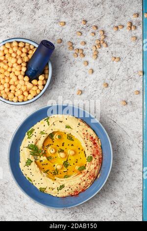 Hummus gekrönt mit ganzen Kichererbsen, Olivenöl und Paprika, typisch für die nahöstliche Küche. Stockfoto