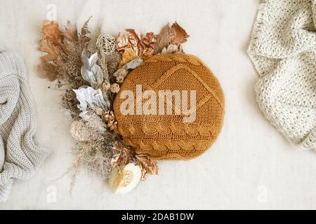 Stillleben mit getrockneten Blumen und gestrickten Elementen auf weißem Hintergrund hautnah. Stockfoto