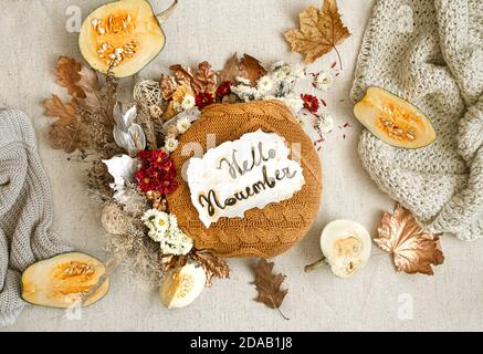 Herbstkomposition mit Blumen, Kürbissen und gestrickten Elementen auf weißem Hintergrund flach legen. Stockfoto