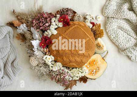 Herbstkomposition mit Blumen, Kürbissen und gestrickten Elementen auf weißem Hintergrund flach legen. Stockfoto