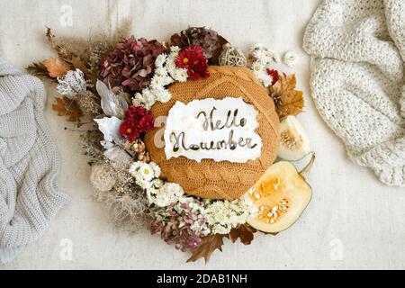 Stillleben im Herbst mit Blumen und gestrickten Elementen auf weißem Hintergrund hautnah. Stockfoto