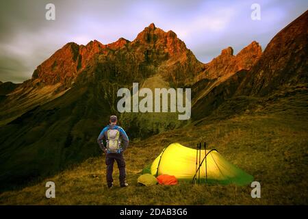 Wandermann mit Rucksack und Zelt am Alpenglow am Großen Wilder in den bayerischen Alpen, Allgau, Deutschland. Stockfoto