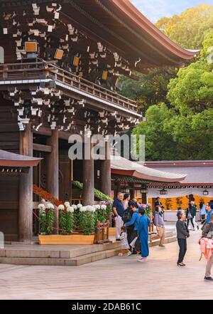 shibuya, japan - november 02 2019: Touristen genießen die Chrysanthemum Blumen vor dem zweistöckigen Tor rōmon namens minami-shinmon in der Shin Stockfoto