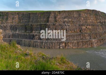 Steile Bänke aus ausgegrabenem Kalkstein im verlassenen Eldon Hill Quarry, zwischen Castleton und Peak Forest, bei Abendsonne, Blick nach Süden. Stockfoto