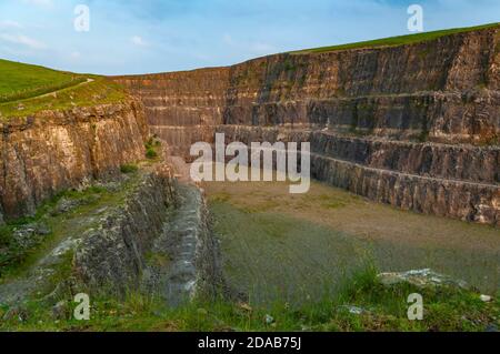 Steile Bänke aus ausgegrabenem Kalkstein im verlassenen Eldon Hill Quarry, zwischen Castleton und Peak Forest, bei Abendsonne, Blick nach Osten. Stockfoto