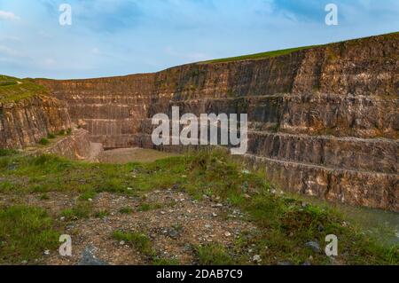 Steile Bänke aus ausgegrabenem Kalkstein im verlassenen Eldon Hill Quarry, zwischen Castleton und Peak Forest, bei Abendsonne, Blick nach Osten. Stockfoto