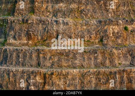 Steile Bänke aus ausgegrabenem Kalkstein im verlassenen Eldon Hill Quarry, zwischen Castleton und Peak Forest, bei Abendsonne, Blick nach Süden. Stockfoto