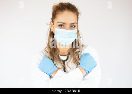Closed up Porträt der kaukasischen Ärztin trägt OP-Maske auf weißem Hintergrund. Stockfoto