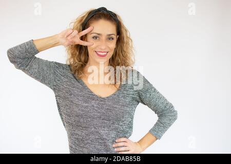 Junge schöne Frau trägt Casual T-Shirt über weiß isoliert Hintergrund tun Frieden Symbol mit Fingern über Gesicht, lächelnd fröhlich zeigt Sieger Stockfoto