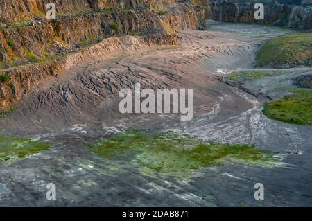 Steile Bänke aus ausgegrabenem Kalkstein im verlassenen Eldon Hill Quarry, zwischen Castleton und Peak Forest, bei Abendsonne, südwestlich blickend. Stockfoto