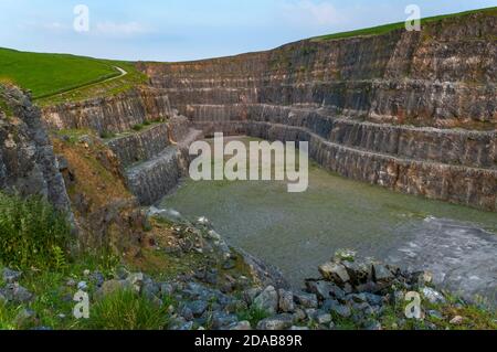 Steile Bänke aus ausgegrabenem Kalkstein im verlassenen Eldon Hill Quarry, zwischen Castleton und Peak Forest, bei Abendsonne, Blick nach Osten. Stockfoto