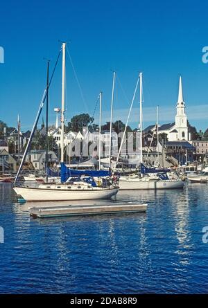 Der charmante Küstenhafen von Camden, Maine, USA, ist die ikonische Stadt New England mit seiner weißen Kirchtürmkirche und einem Hafen voller moderner und klassischer Segelboote. Dazu gehören historische Schoner, die Segeltörns in Penobscot Bay und entlang der nordöstlichen Küste am Atlantischen Ozean anbieten. Stockfoto