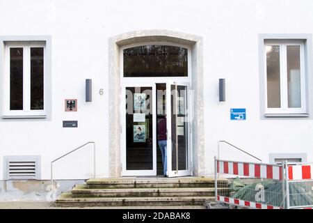 Emmerich Am Rhein, Deutschland. November 2020. Ein Mann geht durch die Tür des Zollbüros. Bei einem spektakulären Einbruchstreich in Emmerich am Niederrhein haben vier Männer rund 6.5 Millionen Euro eingefangen. Die Täter sind entkommen, bisher gibt es keine heiße Führung. Quelle: Federico Gambarini/dpa/Alamy Live News Stockfoto