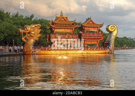 Aufwendige touristische Drachenboot auf West Lake, Hangzhou, China in Golden Hour. Stockfoto