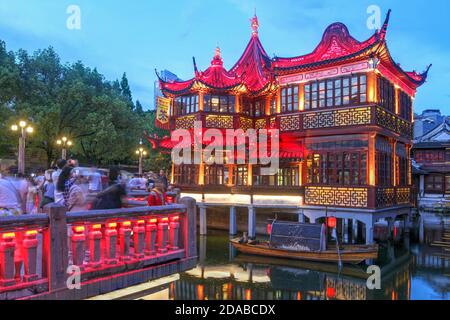 Wunderschön beleuchtetes berühmtes Huxinting Teehaus in Yu Garden, Shanghai, China bei Nacht. Die Struktur, die auf einem Teich sitzt, wird durch ein Zickzack br Stockfoto