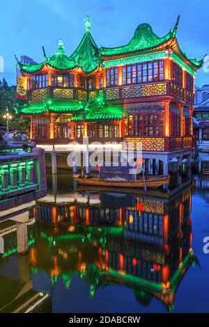 Wunderschön beleuchtetes berühmtes Huxinting Teehaus in Yu Garden, Shanghai, China bei Nacht. Die Struktur, die auf einem Teich sitzt, wird durch ein Zickzack br Stockfoto