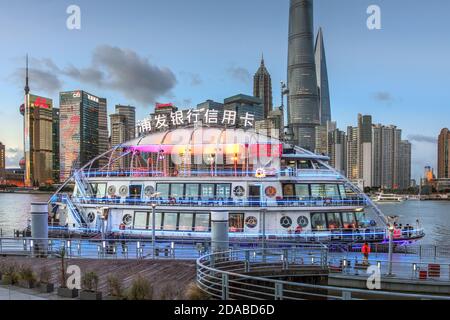 Auffällige Fähre und Flusskreuzfahrtschiff auf dem Bund mit Pudong Skyline im Hintergrund in Shanghai, China. Stockfoto