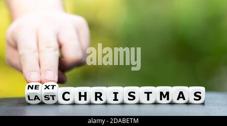 Hand dreht Würfel und ändert den Ausdruck "Last Christmas" zu "Next Christmas". Stockfoto