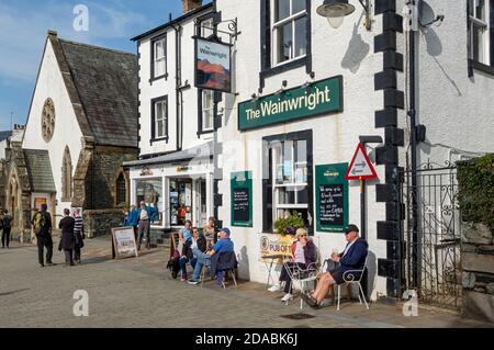 Leute, die draußen sitzen und trinken, sitzen auf der Straße The Wainwright Inn Pub Bar Keswick Lake District Cumbria England Großbritannien Großbritannien Stockfoto