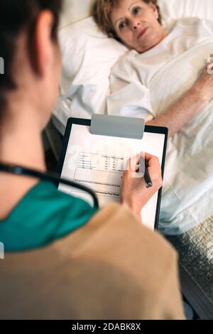 Ärztin Ausfüllen eines Fragebogens Stockfoto